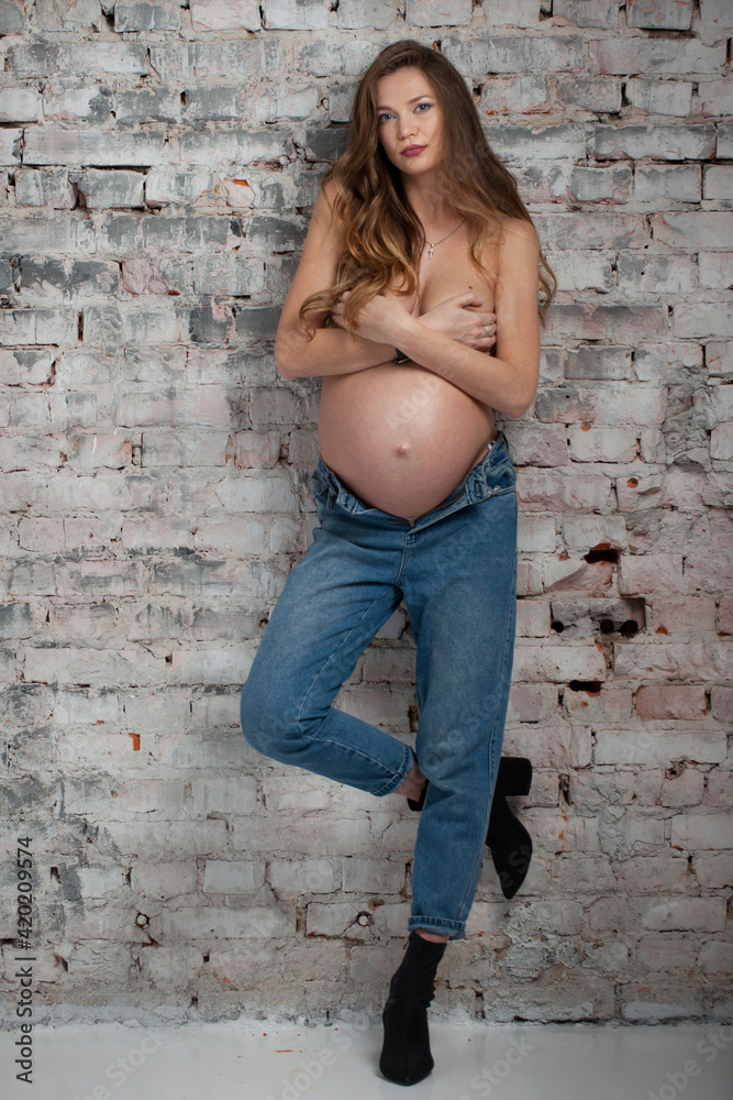 Stylish young pregnant girl, studio photography.