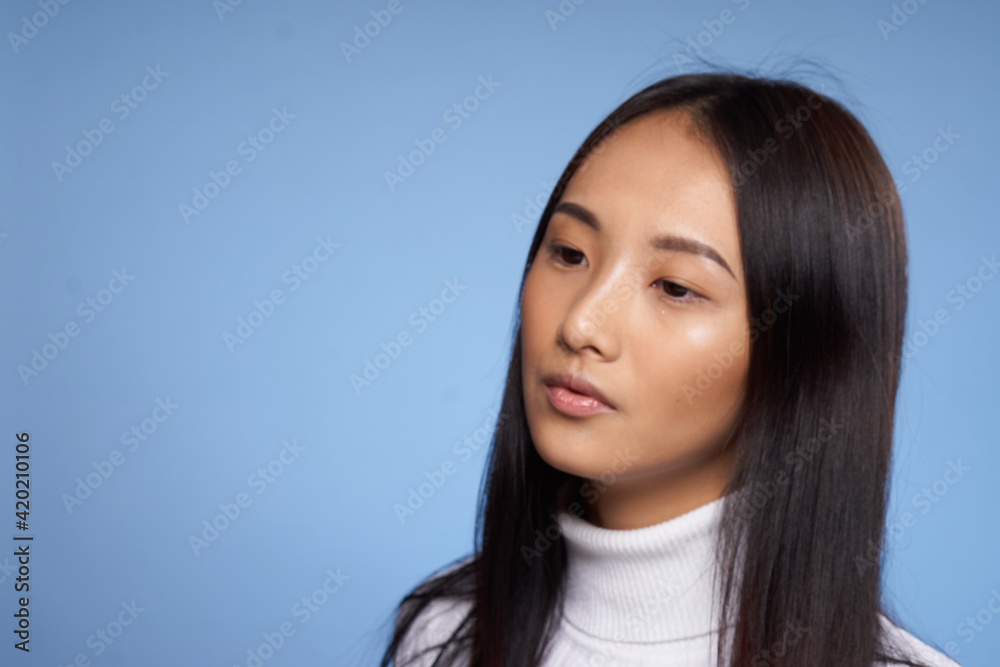 woman asian appearance white jumper blue background close-up model woman asian appearance white jumper blue background close-up model