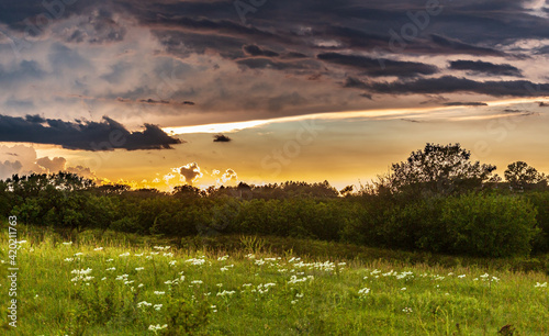 Thunderstorm clouds over a rural landscape at sunset