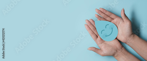 Woman hand holding smile water drop paper cut, world water day, clean water and sanitation, hand sanitizer and hygiene, washing hands, CSR, save water, clean renewable energy concept photo