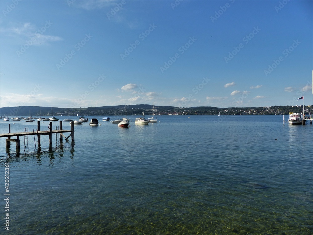Fototapeta premium Bodensee mit Booten und hölzernem Bootssteg