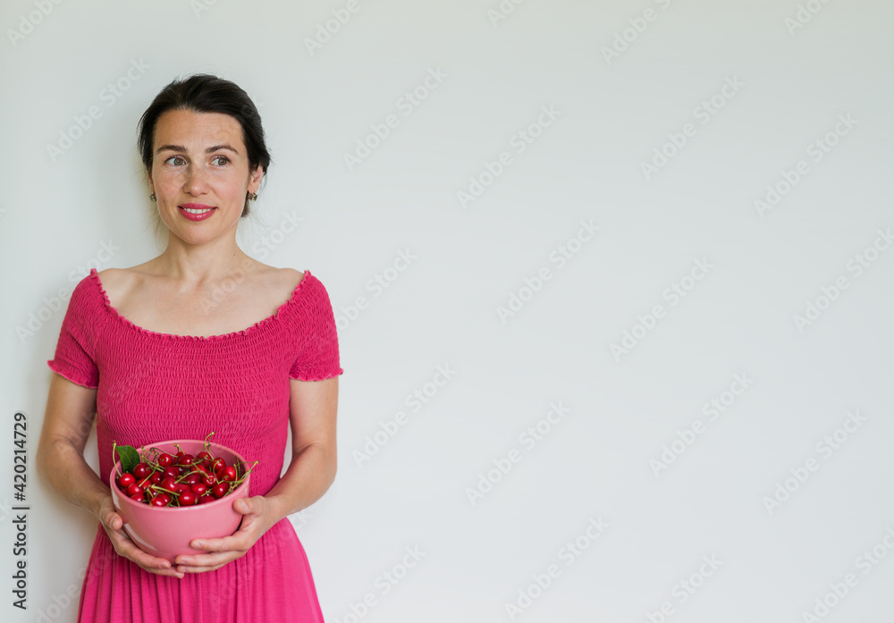 Red ripe cherries in bowl in hands of woman. Healthy eating, vegetarian food concept Red ripe cherries in bowl in hands of woman. Healthy eating, vegetarian food concept