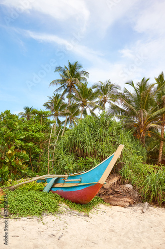 Old small fishing boat by a tropical beach in Sri Lanka.