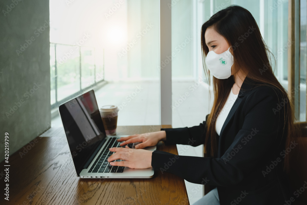 Blur of closeup Asian business woman using technology laptop with safety medical face mask for prevent Coronavirus or Covid19 Outbreak for work from home in modern house. Blur of closeup Asian business woman using technology laptop with safety medical face mask for prevent Coronavirus or Covid19 Outbreak for work from home in modern house.