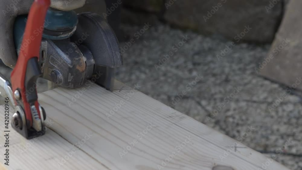 A boy cuts a wooden board with a flex, handmade table A boy cuts a wooden board with a flex, handmade table
