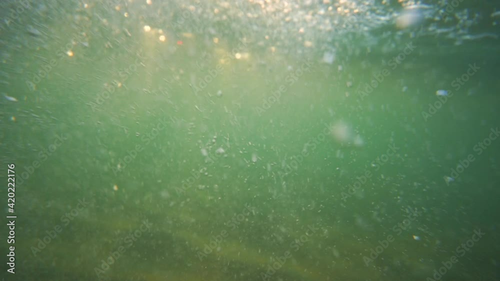 Underwater slow motion view of ripple sea waves, air bubbles and shining sun rays, 4k video Underwater slow motion view of ripple sea waves, air bubbles and shining sun rays, 4k video