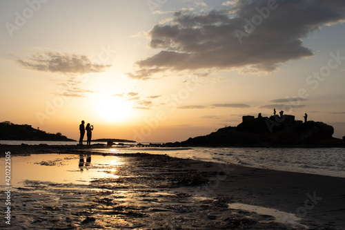 Couple's silhouette at the beach photoshooting the sunset © NIKOS