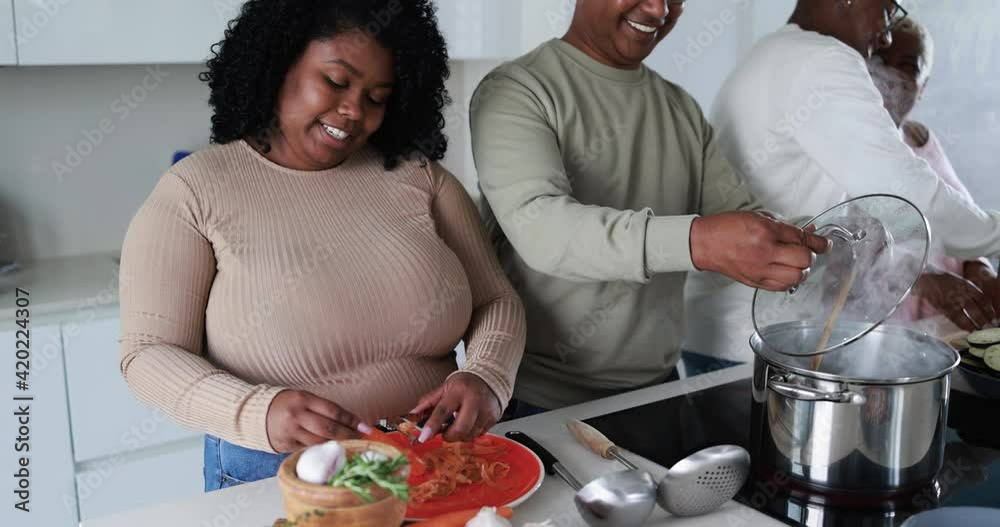 Happy latin family cooking inside kitchen at home - Father, daughter, son and mother having fun preparing lunch 