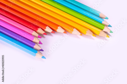 a row of colored pencils on a white background