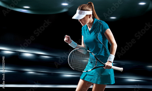 Tennis player with racket. Woman athlete celebrating victory on grand arena background after good play. © Mike Orlov