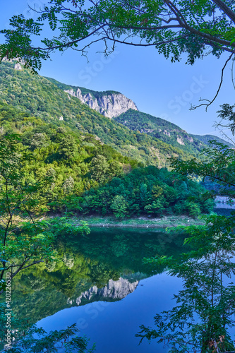  landscape with blue sky and clouds and a peak and a river