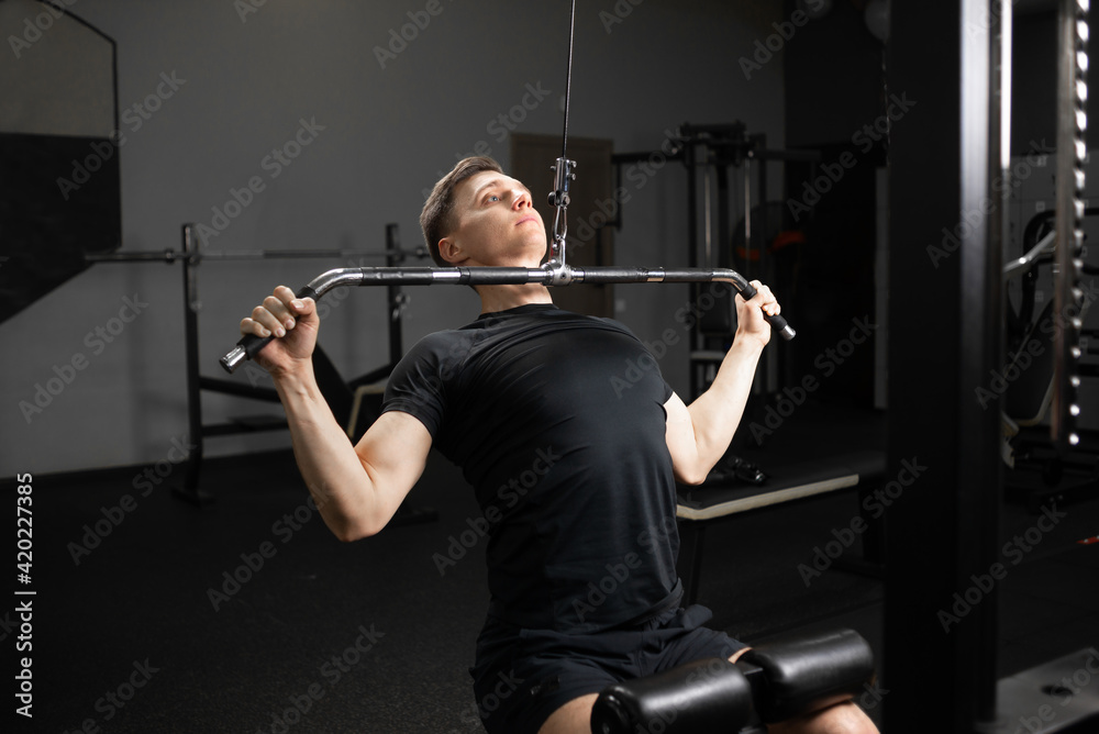 Handsome young man doing bench press, arm and chest trainer. The process of preparing for a powerlifting competition. Handsome young man doing bench press, arm and chest trainer. The process of preparing for a powerlifting competition.