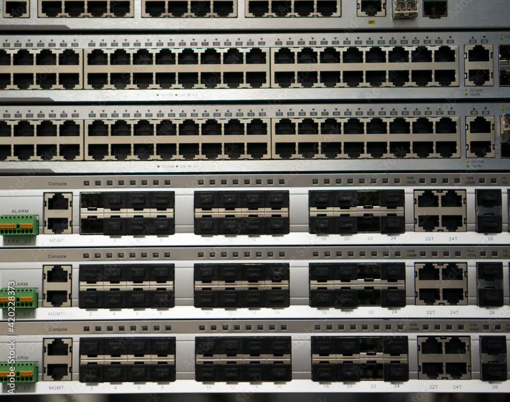 The texture of panels of switches with RJ 45 connectors and optical switches in a closed premises of a telecom operator.