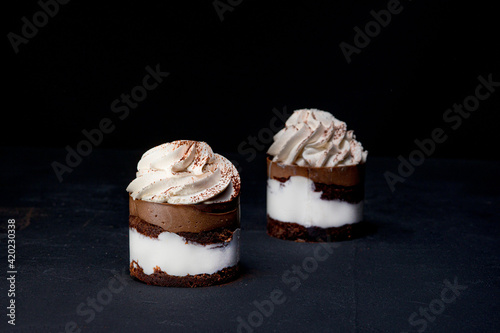 Petit fours or mini chocolate crepe cakes with chocolate on black background