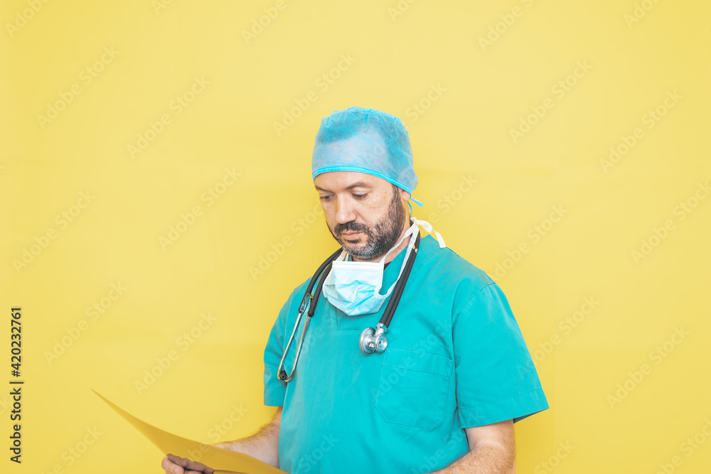Trauma surgeon dressed in operating theatre uniform and stethoscope, reviewing X-ray with a concerned gesture, all against a yellow background. Trauma surgeon dressed in operating theatre uniform and stethoscope, reviewing X-ray with a concerned gesture, all against a yellow background.