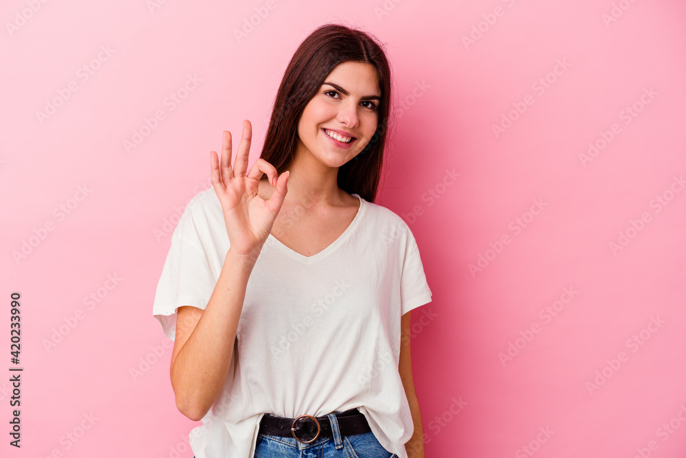 Young caucasian woman isolated on pink background cheerful and confident showing ok gesture. Young caucasian woman isolated on pink background cheerful and confident showing ok gesture.