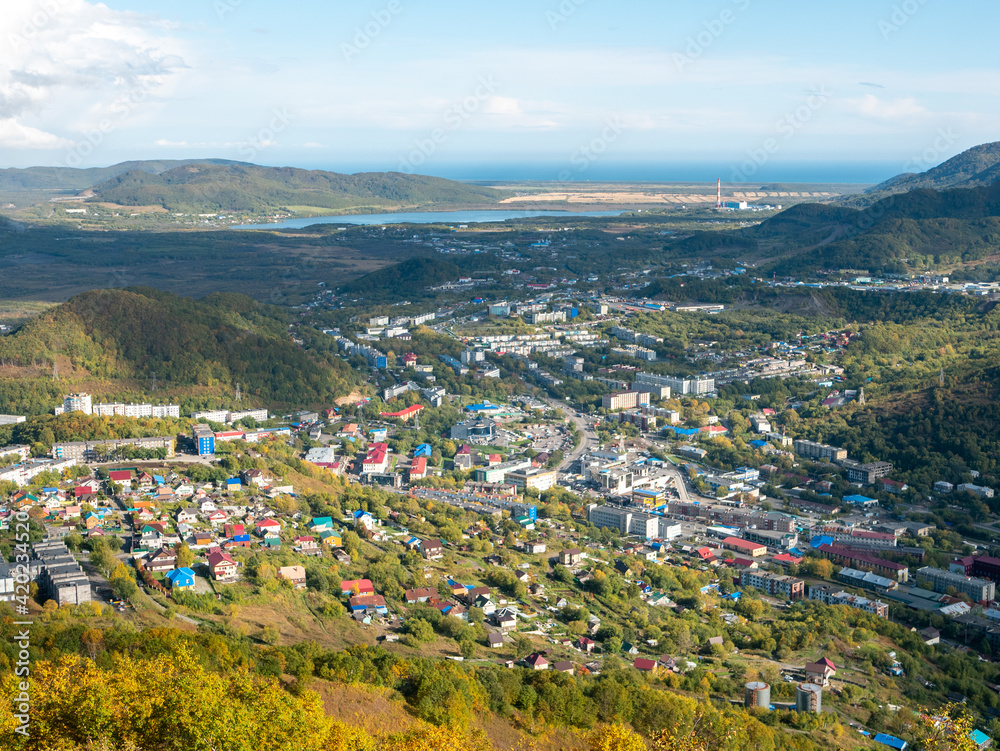 View of the city of Petropavlovsk-Kamchatsky from Mishennaya Sopka. Magnificent aerial view of the Pacific Ocean and green hills. Kamchatka Peninsula, Russia.