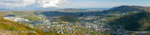 Panorama view of the city of Petropavlovsk-Kamchatsky from Mishennaya Sopka. Magnificent aerial view of the Pacific Ocean and green hills. Kamchatka Peninsula, Russia.