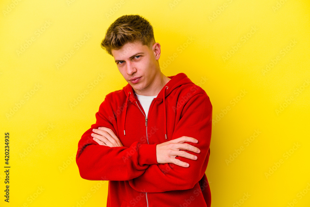Young caucasian man isolated on yellow background suspicious, uncertain, examining you. Young caucasian man isolated on yellow background suspicious, uncertain, examining you.