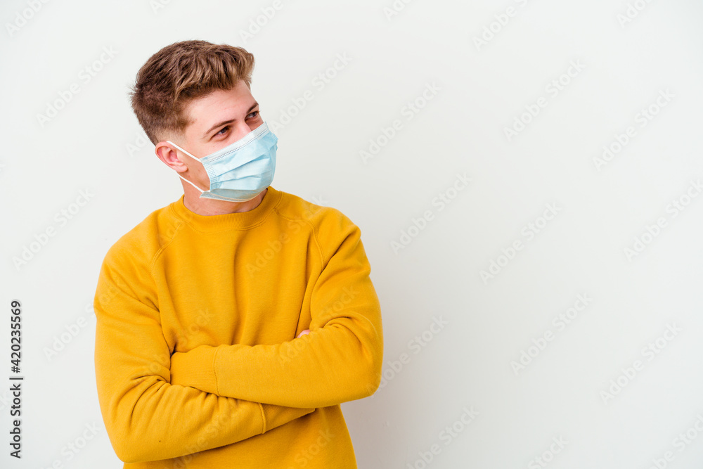 Young man wearing a mask for coronavirus isolated on white background smiling confident with crossed arms. Young man wearing a mask for coronavirus isolated on white background smiling confident with crossed arms.