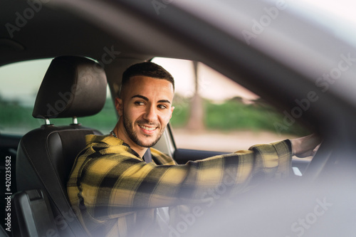 Wallpaper Mural Chico joven guapo en la posicion de conductor de un coche sonriendo Torontodigital.ca