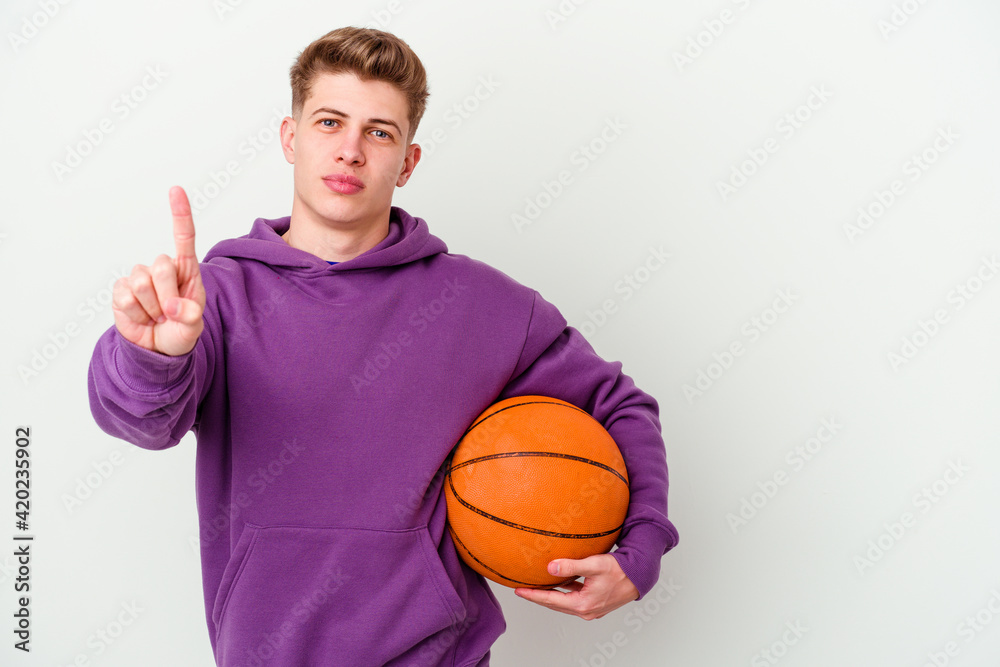 Young caucasian man playing basketball isolated background showing number one with finger. Young caucasian man playing basketball isolated background showing number one with finger.