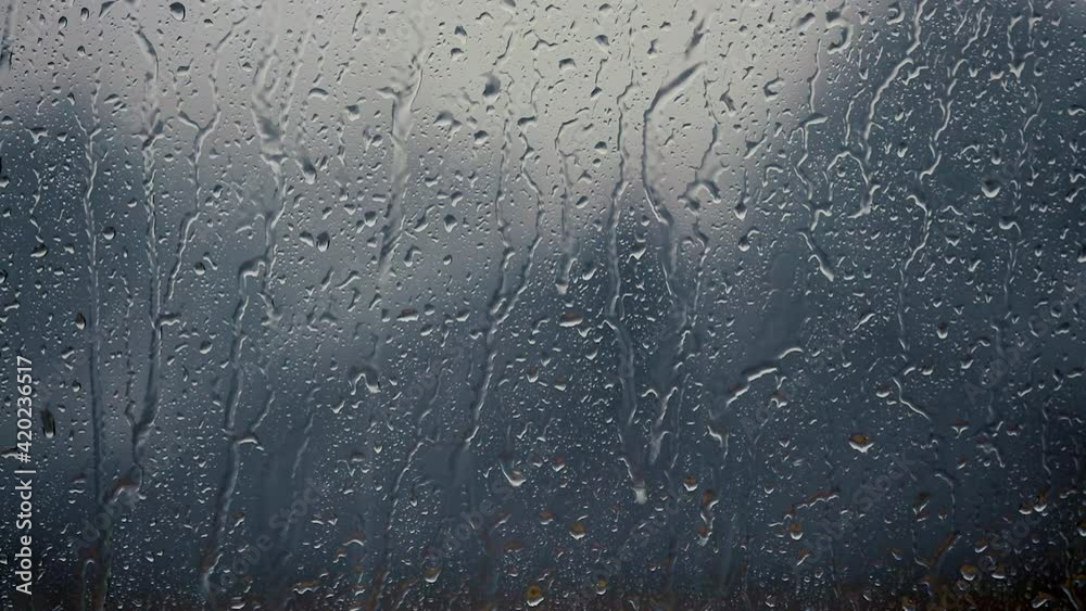 heavy rain falling on window surface