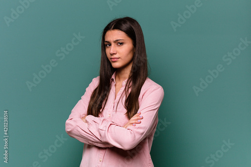 Young Indian woman isolated on blue background suspicious, uncertain, examining you.