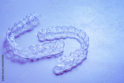 Invisible aligner teeth retainers on a blue background