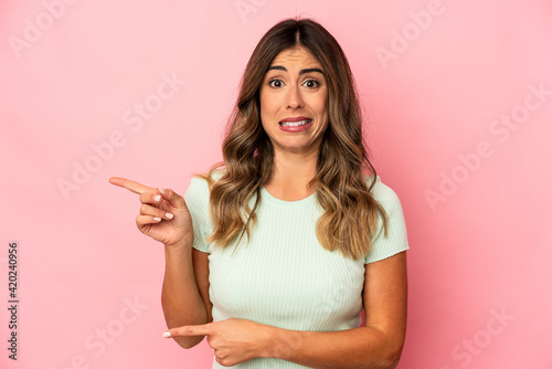 Young caucasian woman isolated shocked pointing with index fingers to a copy space. © Asier