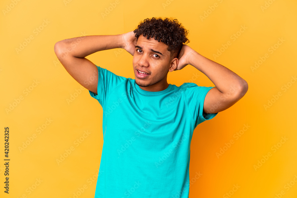 Young african american curly man isolated on purple touching back of head, thinking and making a choice. Young african american curly man isolated on purple touching back of head, thinking and making a choice.