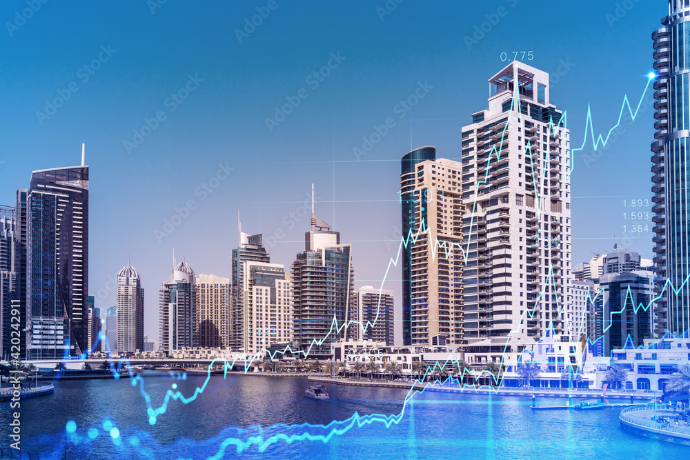 Fototapeta premium Skyscrapers of Dubai business downtown. International hub of trading and financial services of Western Asia. FOREX graph and chart concept. Double exposure. Dubai Canal waterfront.