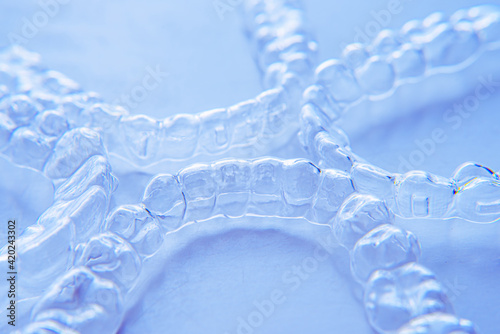 Invisible aligner teeth retainers on a blue background