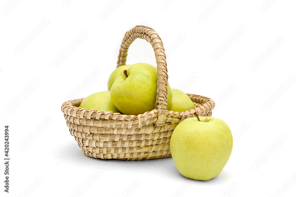 Juicy golden delicious apples in a wicker basket isolated on a white background