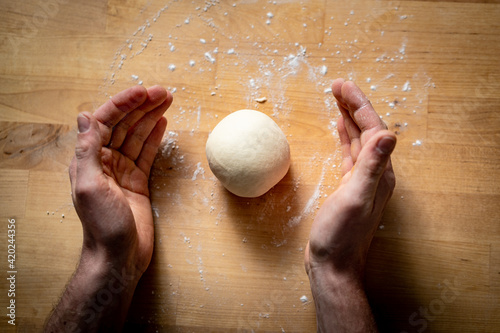 person preparing pizza dough balls