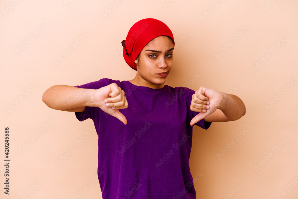 Young african american woman isolated on beige background showing thumb down, disappointment concept.