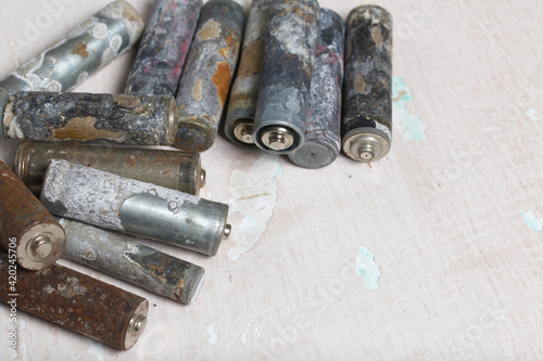 Corroded used batteries. They lie on a light surface. Close-up shot.