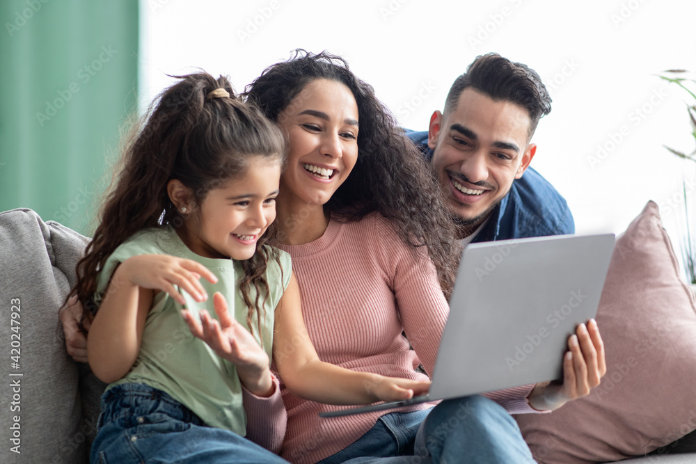 Happy Arabic Family Of Three Making Video Call With Laptop At Home Happy Arabic Family Of Three Making Video Call With Laptop At Home