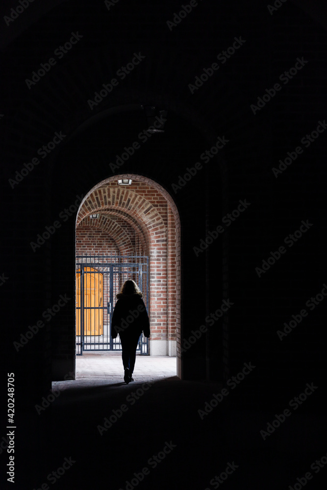 Fototapeta premium Stockholm, Sweden A woman walks under an archway in an outdoor corridor at the Stockholm Stadion Olympic stadium.