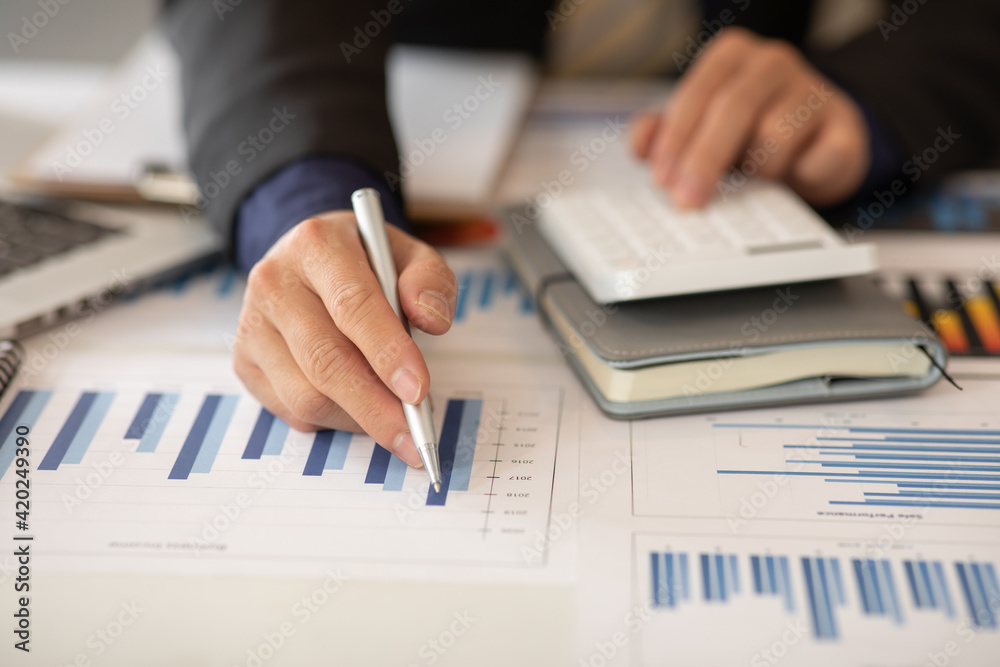 Businessmen are calculating income-expenditure and analyzing real estate investment data, Accounting Financial and tax systems concept. Businessmen are calculating income-expenditure and analyzing real estate investment data, Accounting Financial and tax systems concept.