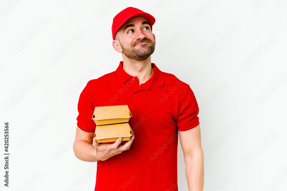 Young caucasian delivery man isolated on white background dreaming of achieving goals and purposes Young caucasian delivery man isolated on white background dreaming of achieving goals and purposes