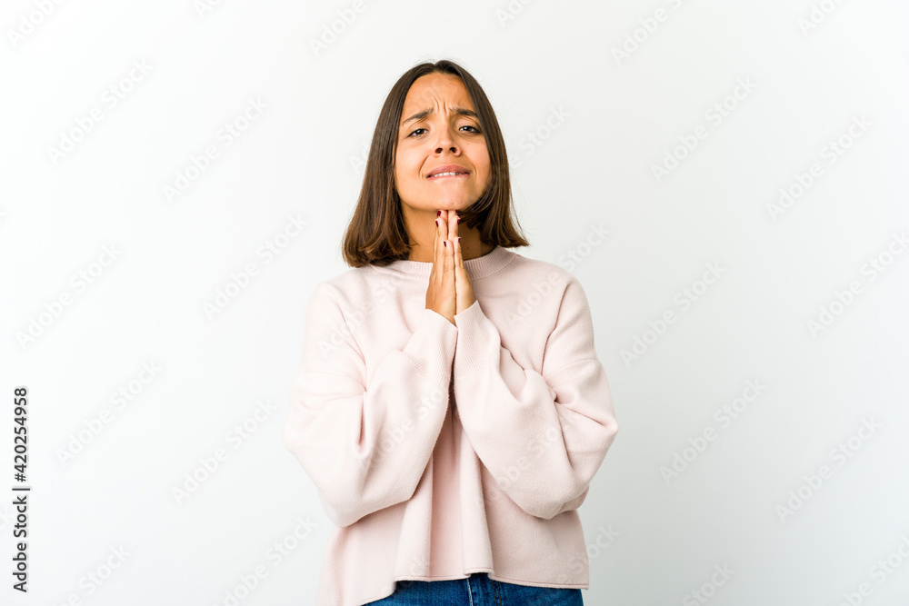 Young mixed race woman holding hands in pray near mouth, feels confident. Young mixed race woman holding hands in pray near mouth, feels confident.