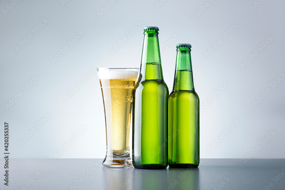 Glass Of Beer With Bottles On Grey Background. Non Alcoholic Beer. Glass Of Beer With Bottles On Grey Background. Non Alcoholic Beer.