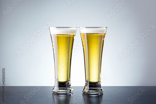 Two glass beer on dark counter against grey background with copy space.