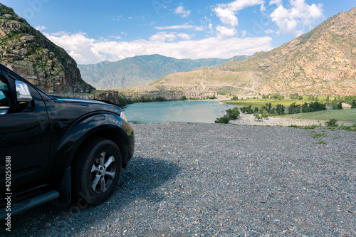 Travel concept with car against river and mountains.