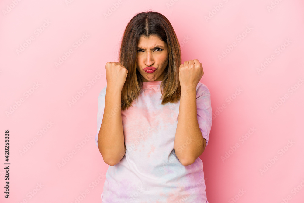 Young indian woman isolated on pink background upset screaming with tense hands. Young indian woman isolated on pink background upset screaming with tense hands.