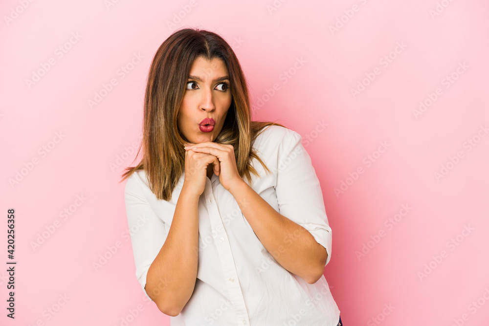 Young indian woman isolated on pink background praying for luck, amazed and opening mouth looking to front. Young indian woman isolated on pink background praying for luck, amazed and opening mouth looking to front.