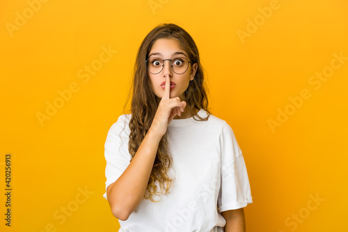 Young caucasian woman keeping a secret or asking for silence.