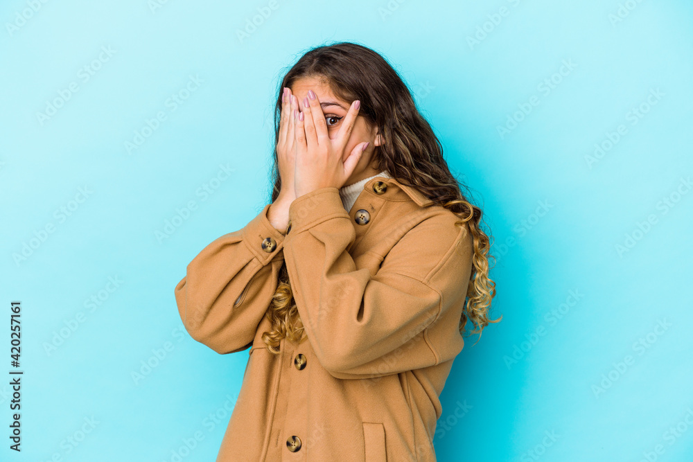 Young caucasian curly hair woman isolated blink through fingers frightened and nervous. Young caucasian curly hair woman isolated blink through fingers frightened and nervous.