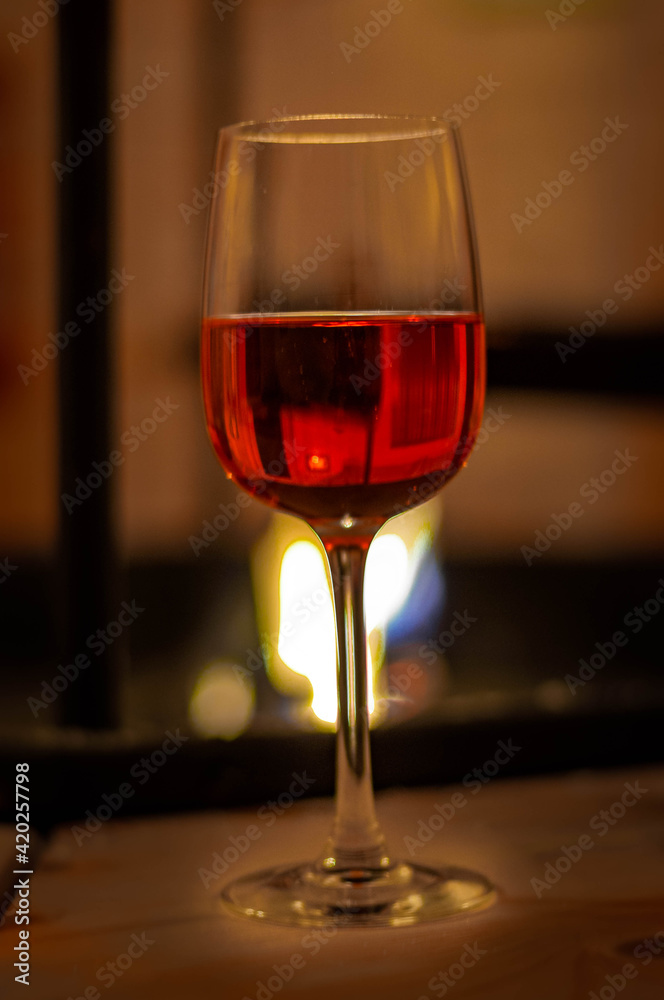 red wine in a glass in a glass cup against the background of a campfire and barbecue